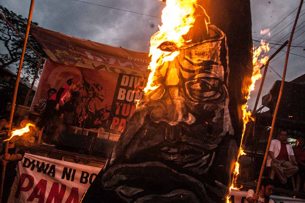 A painting with the image of President Aquino is burned during the program at Mendiola bridge. Progressive groups push for his ouster due to his alleged criminal neglect and violations against the people.